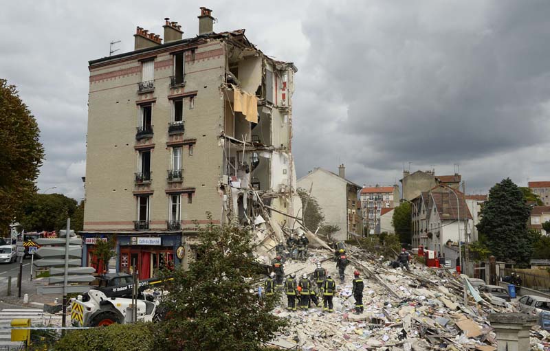 Firefighters search through the rubble of a four-storey residential building that collapsed following a blast in Rosny-sous-Bois in the eastern suburbs of Paris on August 31, 2014. A four-storey residential building collapsed in a Paris suburb following an explosion possibly due to a gas leak, killing at least one child and an elderly woman, local emergency services said. Ten people were also wounded, including four in serious condition, while 11 others are still unaccounted for. AFP PHOTO / BERTRAND GUAY