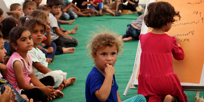 Young Iraqi's, that fled violence in the northern city of Tal Afar due to attacks by Islamic State (IS) jihadists, take  a class at a make-shift school in a tent at the Bahrka camp, 10 km west of Arbil in the autonomous Kurdistan region, on September 1, 2014. About 700,000 Iraqis have gathered in the Kurdish north after being driven from their homes by jihadist fighters, the United Nations said as it stepped up a massive aid operation to the region. AFP PHOTO / SAFIN HAMED
