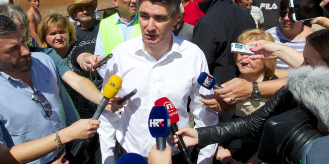  Rajevo Selo, 090714.Predsjednik Vlade Republike Hrvatske Zoran Milanovic posjetio je Gunju, Rajevo Selo i Drenovce. Premijer je zajedno s ministricom graditeljstva i prostornog uredjenja Ankom Mrak-Taritas obisao kuce na kojima su poceli gradjevinski radovi u sklopu Vladinog programa obnove poplavom stradalih podrucja.Na fotografiji: premijer Zoran Milanovic u Rajevom Selu novinarima je dao izjavu ispred kuce Ljiljane Jerkovic kojoj je prosli tjedan rekao da razumije njenu situaciju jer je i njemu pukla vodovodn a cijev u kuci.Foto: Vlado Kos / Cropix