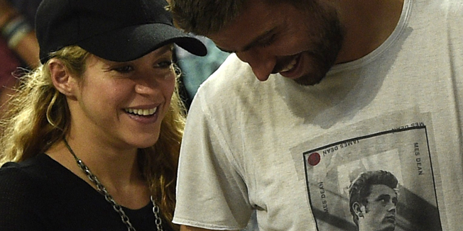 FC Barcelona's defender Gerard Pique (R) and his wife Colombian singer Shakira attend the 2014 FIBA World basketball championships quarter-final match Slovenia vs USA at the Palau Sant Jordi arena in Barcelona on September 9, 2014.  AFP PHOTO / LLUIS GENE