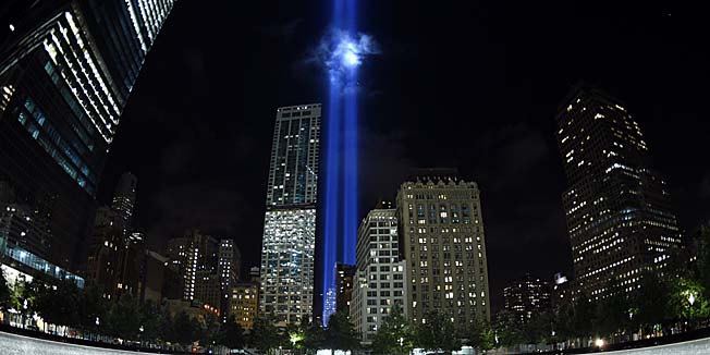The Tribute in Light illuminates the sky  behind the  9/11 Memorial waterfalls and reflecting pool in New York on September 10, 2014, the night before the 13th anniversary of the September 11, 2001 attacks. The tribute, an art installation of the Municipal Art Society, consists of 88 searchlights placed next to the site of the World Trade Center creating two vertical columns of light in remembrance of the 2001 attacks. AFP PHOTO /  TIMOTHY  A. CLARY
