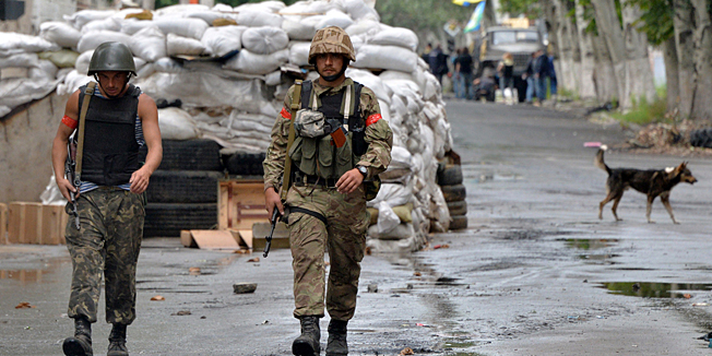 Ukrainian servicemen walk in the center of the Ukrainian city of Slavyansk on July 6, 2014. Government forces hoisted the Ukrainian flag over the pro-Russian rebels' main stronghold of Slavyansk on July 5 after flushing them out of the eastern industrial city, the defence minister said. AFP PHOTO / GENYA SAVILOV