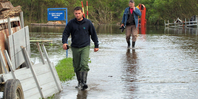 Sisak, 180914.Iako vodostaji Kupe i Save u Sisku opadaju, zaobalne vode iz Odranskog polja pocele su plaviti sisacka prigradska naselja.U Skolskoj ulici u Selima voda je vec opkolila nekoliko kuca i rast ce jos najmanje tri dana.Mjestani su kuce ogradili vrecama s pijeskom, a tijekom poplave u veljaci ove gdoienj u Skolskoj ulici u Selima pod vodom je bilo pedesetak kuca.Na fotografiji: Poplavljeni dio Skolske ulice.Foto: Mate Piskor / CROPIX                                     