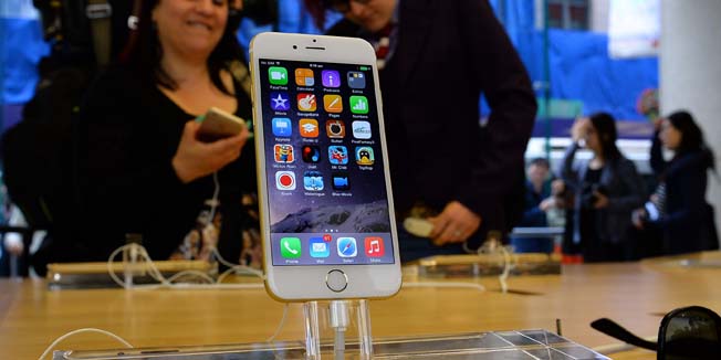 Potential customers check a display unit of the new iPhone 6 at the Apple flagship store in Sydney on September 19, 2014. Hundreds of people queued through the night in Sydney to be among the first in the world to get their hands on the new Apple iPhone 6 models with the large-screen handsets drawing keen interest. AFP PHOTO / Saeed KHAN
