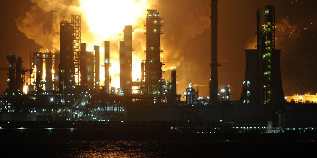 Flames arise after a fire broke out at the Mediterranean Refinery of Milazzo, one of most important in southern Italy, in Milazzo, near Messina on Sicily Island on September 27, 2014.  Mediterranean Refinery of Milazzo contains a million gallons of fuel. AFP PHOTO/GIOVANNI ISOLINO