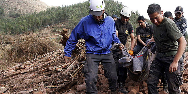 This hand out picture released by Andina national news agency shows rescue workers carrying a body on a stretcher among the ruins of the Andean village of Mica on Septmber 28, 2014, after an earthquake shook the town on the evening of September 27. At least eight people died, including four children, and more than 150 residents in Mica and neighbouring towns in the Paruro District close to Cuzco have lost their homes. AFP PHOTO/ANDINA/HO --- RESTRICTED TO EDITORIAL USE - MANDATORY CREDIT 
