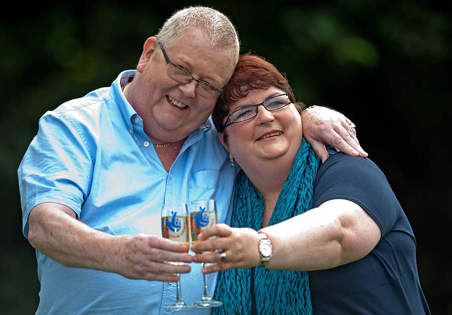 Colin Weir (L) and his wife Chris pose for pictures with champagne during a photocall in Falkirk, Scotland, on July 15, 2011, after winning a record GBP161m (184m euros/259m USD) in the EuroMillions Lottery, on July 15, 2011.  The Euro Millions lottery, launched in 2004, is now played by nine countries across western Europe: Austria, Belgium, Britain, France, Ireland, Luxembourg, Portugal, Spain and Switzerland. AFP PHOTO/ WATTIE CHEUNG