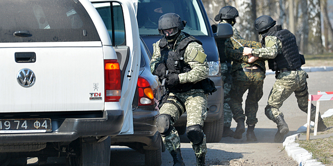 Former pro-European Maidan self-defence activist who are now reservists in the newly founded Ukrainian National Guard take part in military exercises at a shooting range not far from Kiev on March 31, 2014, in the presence of the Ukrainian speaker of the parliament and interim president. Ukraine today reported a gradual withdrawal of Russian troops from its border that may be linked to Washington's latest push for a diplomatic solution to the worst East-West standoff since the Cold War. AFP PHOTO / SERGEI SUPINSKY