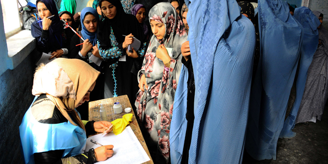 Afghan women register their names to vote at a polling station in the northwestern city of Herat on April 5, 2014. Afghan voters went to the polls to choose a successor to President Hamid Karzai, braving Taliban threats in a landmark election held as US-led forces wind down their long intervention in the country. AFP PHOTO/AREF KARIMI