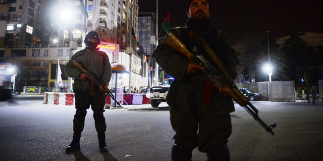 Afghan policemen block a road as they stands guard near the security perimeter setup around the Serena hotel in Kabul late on March 21, 2014. Security forces rushed to the luxury Serena hotel in central Kabul on March 20 evening after gunshots were heard at the venue, a high-security location favoured by foreign visitors to the Afghan capital. The gunfire at the hotel came on the same day that seven Taliban suicide attackers stormed a police station in the eastern city of Jalalabad killing 10 policemen. AFP PHOTO / SHAH MARAI