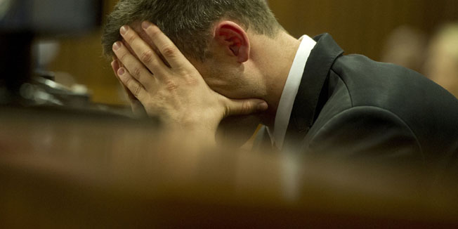 South African Paralympic track star Oscar Pistorius react during his trial in Court in Pretoria on April 7, 2014. As the defence opens its case, the 27-year-old Paralympian will give the court his first account of why he shot dead his model girlfriend Reeva Steenkamp in the early hours of Valentine's Day in 2013.  AFP PHOTO / POOL / Deaan Vivier