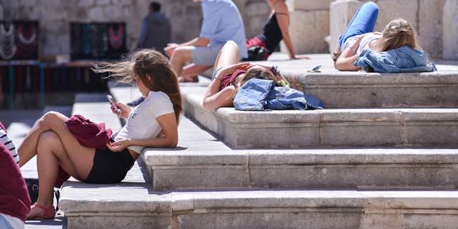 Dubrovnik,100414.Pocele su stizati prve grupe gostiju u Dubrovnik pa je sa njima ozivjela i stara gradska jezgra. Turisti su uzivali u suncanom danu.Na fotografiji: Turisti se suncaju na skalinima Katedrale.Foto: Tonci Plazibat / CROPIX