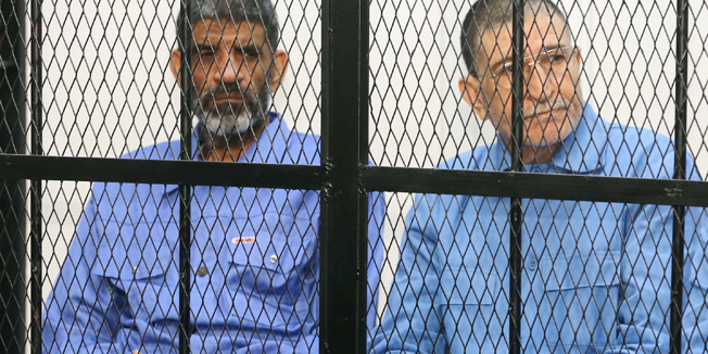 Former Libyan intelligence chief Abdullah al-Senussi (L), and former Libyan foreign intelligence chief Bouzid Dorda, attend their trial at the appeals court in Tripoli, on April 14, 2014. The main charges against the suspects include murders committed during the regime's battle against the revolt that erupted in the eastern city of Benghazi in February 2011. AFP PHOTO/MAHMUD TURKIA