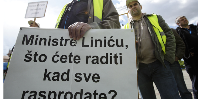 Zagreb, 150414.Sindikat hrvatskih zeljeznicara organizirao je prosvjed zbog otpustanja radnika HZ Carga, te namjere otpustanja radnika HZ Putnickog prijevoza. Prosvjed je zapoceo u sjedistu SHZ-a u Strojarskoj, a nastavljen ispred sjedista HZ Infrastrukture i HZ Putnickog prijevoza u Mihanovicevoj,  a zatim i ispred sjedista HZ Carga na Trgu Kralja Tomislava.Na fotografiji: prosvjednici s transparentom.Foto: Dragan Matic / CROPIX