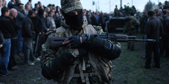 Armed pro-Russia activists block a collumn of Ukrainian men riding on Armoured Personnel Carriers in the eastern Ukrainian city of Kramatorsk on April 16, 2014. Ukraine's security service said on April 16 it had intercepted communications showing that Russian commanders in the separatist east had issued pro-Kremlin militants 