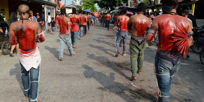 Penitents flagellate themselves as part of Lenten observance in Angeles City, Pampanga province, north of Manila on April 17, 2014. The dominant Roman Catholic church does not condone flagellation and other extreme acts of penitence including gory Good Friday reenactments of the crucifixion of Jesus Christ, but devout Catholics say it is a means of atoning for their sins and to implore God to spare them and other members of their families from illness or bad luck.      AFP PHOTO/TED ALJIBE