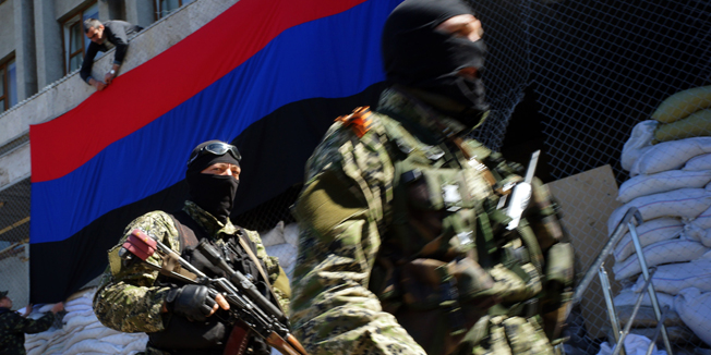 A pro-Russia activist hangs a flag of the so-called 