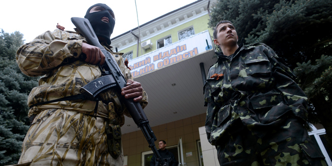 Armed men in military fatigues stand guard outside the police regional building seized by the separatists in the eastern Ukrainian city of Kramatorsk on April 22, 2014. US Vice President Joe Biden met Ukraine's new pro-Western leaders Tuesday to offer firm American backing as Washington and Moscow traded blame over an unravelling peace deal to defuse the country's deep crisis. Under the deal signed by Ukraine, Russia, the United States and the European Union last week, pro-Kremlin rebels holding a string of eastern towns were supposed to disarm and give up the state buildings they have seized. AFP PHOTO/KIRILL KUDRYAVTSEV