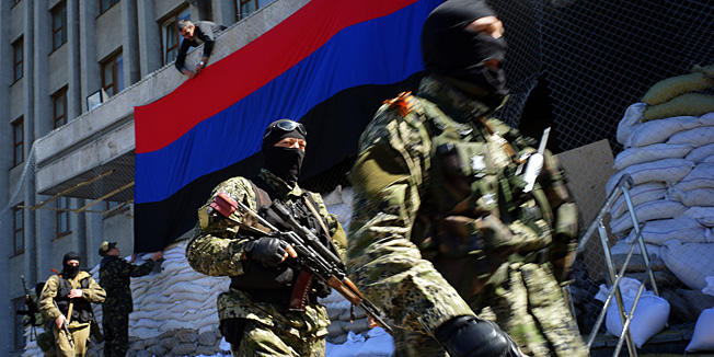 A pro-Russia activist hangs a flag of the so-called 