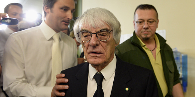 Formula One supremo Bernie Ecclestone (C) leaves the court room during a break of his trial in Munich, southern Germany, on April 24, 2014. Ecclestone went on trial accused of bribery in a case which threatens a jail term for the Briton. AFP PHOTO / CHRISTOF STACHE