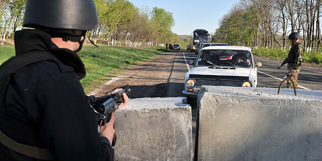 Ukrainian policemen stand guard at their newly erected checkpoint near the eastern Ukrainain city of Slavyansk on April 25, 2014. Ukraine's army on April 25 launched an operation to ensnare pro-Russia militants in the flashpoint eastern city of Slavyansk in a bid to prevent reinforcements and keep civilian casualties down, authorities said. AFP PHOTO/ GENYA SAVILOV