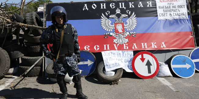 A pro-Russian armed man guards a check point outside the eastern Ukrainian city of Slavyansk, on April 26, 2014. Seven members of an OSCE observer mission in Ukraine were seized by rebels today and being held in the eastern flashpoint town of Slavyansk, the interior ministry in Kiev said. AFP PHOTO / MAX VETROV