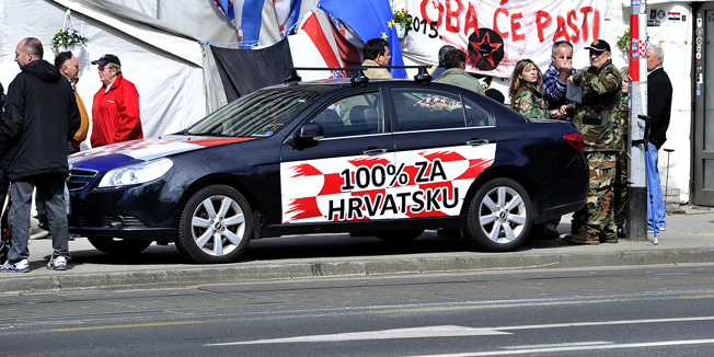 Zagreb, 300315.  Savska 66.Branitelj, ispred satora u Savskoj 66, pokazivanjem srednjeg prsta iskazuje nezadovoljstvo zbog fotografiranja.Foto: Boris Kovacev / CROPIX