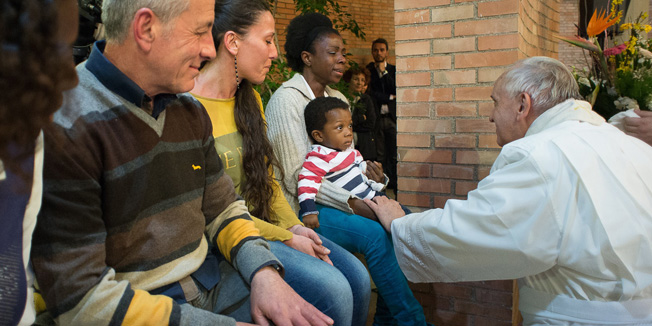 This handout picture released by the Vatican press office shows Pope Francis touches the hand of a woman as he washes the feet of prisoners during a ceremony at the Rebibbia prison in Rome on Holy Thursday on April 2, 2015. The traditional 
