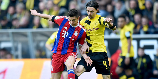 DORTMUND, GERMANY - APRIL 04: Robert Lewandowski of Bayern Muenchen is challenged by Neven Subotic of Borussia Dortmund during the Bundesliga match between Borussia Dortmund and FC Bayern Muenchen at Signal Iduna Park on April 4, 2015 in Dortmund, Germany.  (Photo by Lars Baron/Bongarts/Getty Images)