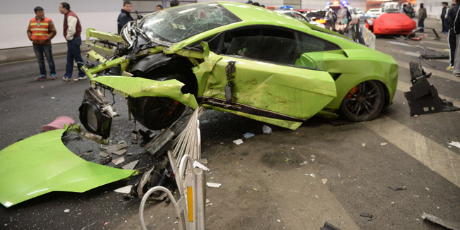 This photo taken early on April 12, 2015 shows a badly damaged Lamborghini car (C) and debris in a tunnel after a crash involving a Ferrari (behind R) in Beijing. The two cars crashed late on April 11 in a high-speed road race in Beijing as the seventh stunt-filled 
