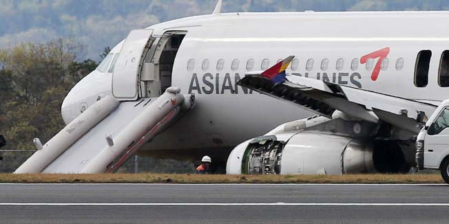 An Asiana Airlines Airbus A320 aircraft is seen with its evacuation slides deployed after it overran a runway at the Hiroshima airport in Mihara in Hirishima prefecture, western Japan on April 15, 2015. More than 20 passengers were injured when an Asiana Airlines Airbus A320 overran a runway at the Hiroshima airport on April 14. The South Korean carrier's Flight OZ162, which took off at Incheon airport, was attempting to land in Hiroshima when the incident occurred.  AFP PHOTO / JIJI PRESS    JAPAN OUT