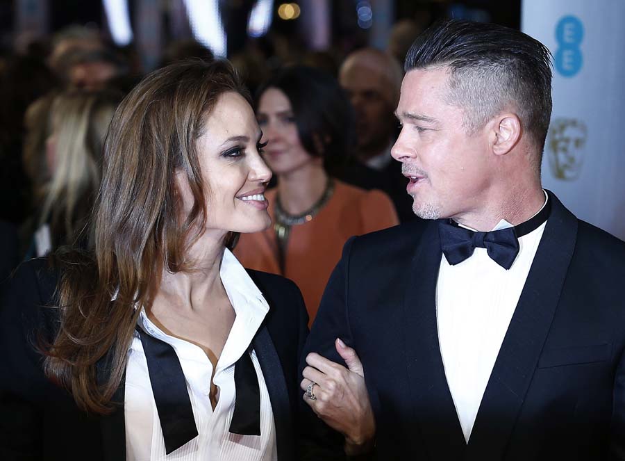 US actor Brad Pitt (R) and actress Angelina Jolie arrive on the red carpet for the BAFTA British Academy Film Awards at the Royal Opera House in London on February 16, 2014. AFP PHOTO / ANDREW COWIE