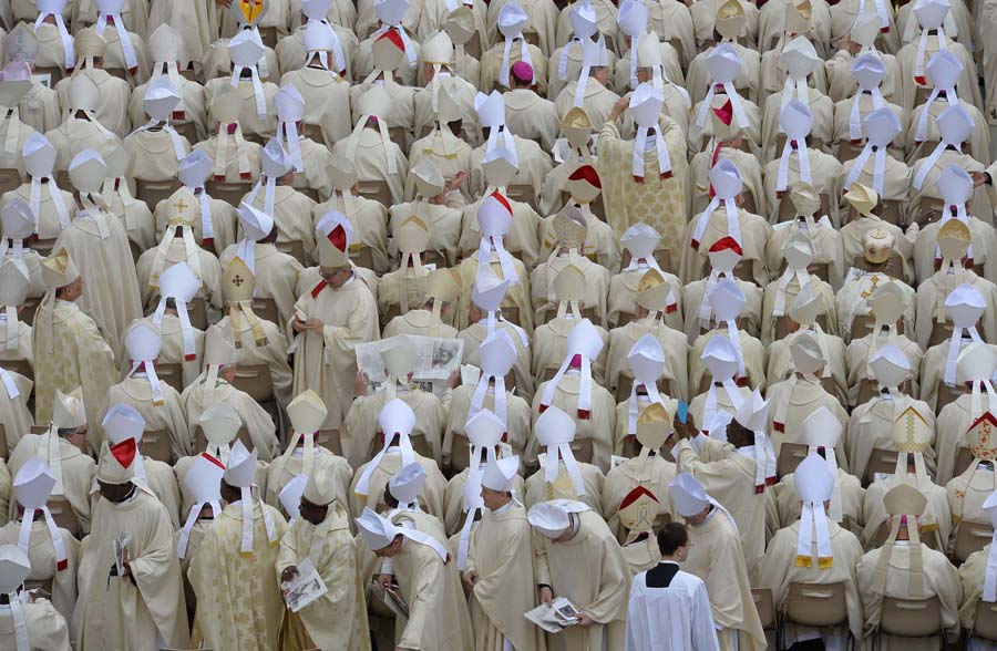 Bishops take their seats before the canonisation mass of Popes John XXIII and John Paul II on St Peter's at the Vatican on April 27, 2014. Catholics from around the world gathered in Rome on Sunday for a mass presided by Pope Francis to confer sainthood on John Paul II and John XXIII -- two influential popes who helped shape 20th century history.     AFP PHOTO / ANDREAS SOLARO