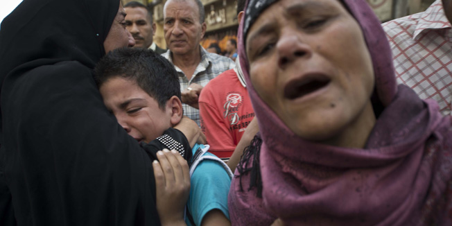 Egyptians react outside the courtroom in Egypt's southern province of Minya after an Egyptian court sentenced Muslim Brotherhood leader Mohamed Badie and other alleged Islamists to death on April 28, 2014. The defendants were accused of involvement in the murder and attempted murder of policemen in Minya province on August 14, the day police killed hundreds of ousted Islamist president Mohamed Morsi's supporters in clashes in Cairo. AFP PHOTO / KHALED DESOUKI