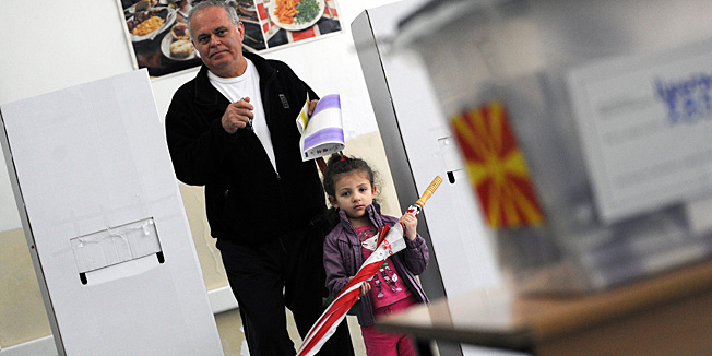 A man, accompanied by his child, prepares to cast his ballot at a polling station in Skopje on April 27, 2014. Macedonians trickled to the polls today to elect a new assembly and president, with the ruling conservatives tipped to cement their hold on power despite widespread poverty and a stalemate in Skopje's bid to join the EU. AFP PHOTO / ROBERT ATANASOVSKI