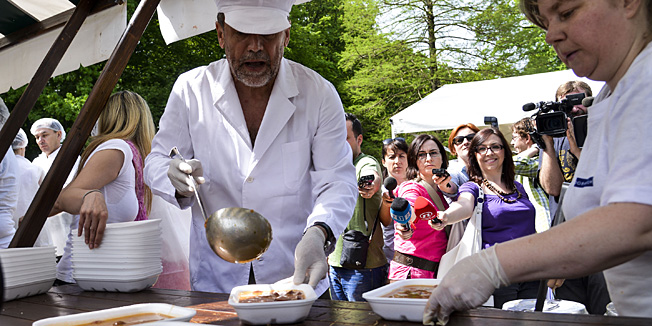 Zagreb, 010513.Proslava povodom Medjunarodnog praznika rada u parku Maksimir. Brojni Zagrepcani su posjetili Maksimir gdje su mogli besplatno  pojesti grah, prosetati se, veslati na jezeru, uzivati u prigodnom kulturnom programu i drugim aktivnostima. Na slici: Milan Bandic dijeli grah.Foto: Admir Buljubasic / CROPIX