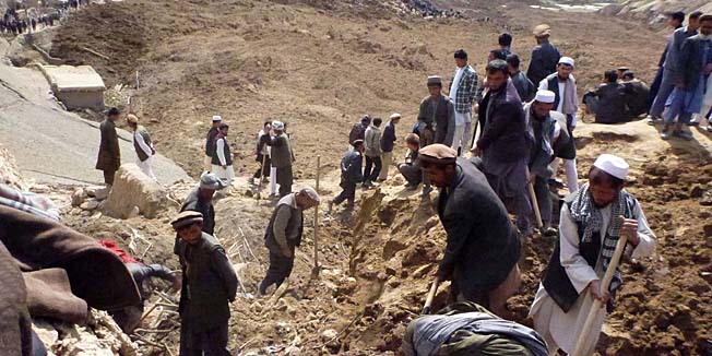 Afghan volunteers search for survivors in Argo district of Badakhshan province on May 3, 2014 after a massive landslide May 2 buried a village. Rescuers searched in vain for survivors May 3 after a landslide buried an Afghan village, killing 350 people and leaving thousands of others feared dead amid warnings that more earth could sweep down the hillside. Local people made desperate efforts to find victims trapped under a massive river of mud that engulfed Aab Bareek village in Badakhshan province, where little sign remained of hundreds of destroyed homes. AFP PHOTO/Sharif Shayeq