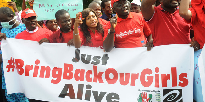 Members of civil society groups shout slogans  to protest the abduction of Chibok school girls during a rally pressing for the girls' release in Abuja on May 6, 2014, ahead of World Economic Forum. Members of civil society groups marched through the streets of Abuja and to the Nigerian defence headquarters to meet with military chiefs, to press for the release of more than 200 Chibok school girls abducted three weeks ago. Suspected Boko Haram Islamists have kidnapped eight more girls from Nigeria's embattled northeast, residents said on May 6, after the extremist group's leader claimed responsibility for abducting more than 200 schoolgirls last month and said in a video he was holding them as 