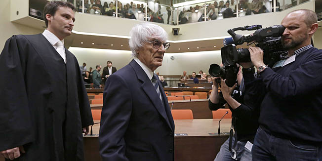 Formula One magnate Bernie Ecclestone (C) is followed by his lawyer Norbert Scharf (L) as he arrives for the third day of his trial in the regional court in Munich, southern Germany, on May 9, 2014. Ecclestone is charged with bribery and incitement to breach of trust 