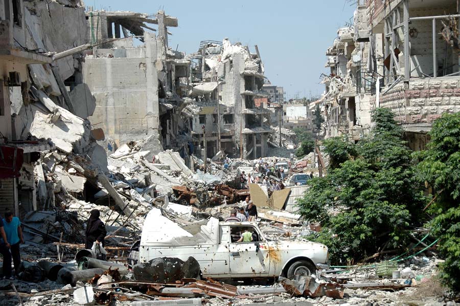 Syrians walk amid debris as they return to the Juret al-Shayah district of the central city of Homs on May 10, 2014, a day after the last Syrian rebels left the city's neighbourhood under an evacuation deal that hands the government a symbolic victory. Rebel forces in the Old City were under government siege for nearly two years before the deal to evacuate, and regime troops shelled the area almost daily throughout. AFP PHOTO / STR