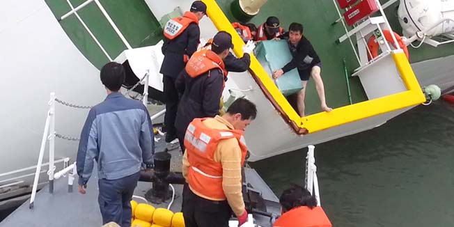 (FILES) A file photo taken on April 16, 2014 and released by the Korean Coastguard on April 28, 2014 shows Sewol ferry captain Lee Joon-Seok (C-R), wearing a sweater and underpants, being rescued from the tilting vessel before it sank.  On May 15, 2014 the captain and three other crew members of the ferry that sank off South Korea last month were indicted on charges of manslaughter through gross negligence, Yonhap news agency reported. ---- EDITORS NOTE ---- RESTRICTED TO EDITORIAL USE MANDATORY CREDIT 