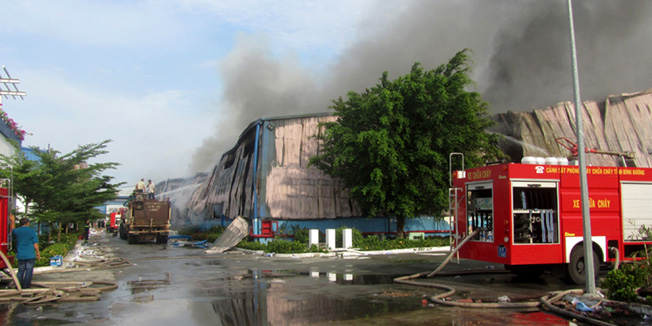 This photo taken on May 14, 2014 shows smoke billowing from a Taiwanese furniture factory in Binh Duong as anti-China protesters set more than a dozen factories on fire in Vietnam, according to state media, in an escalating backlash against Beijing's deployment of an oil rig in contested waters.  The US on May 16, betrayed increasing disquiet over the potential for serious clashes between China and Vietnam over disputed South China Sea territory, calling on both sides to show restraint.  AFP PHOTO