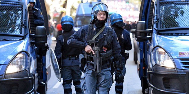 Anti-riot policemen patrol during an anti-austerity protest on October 19, 2013 in Rome. Between 3,000 and 4,000 police officers have been deployed, Italian media reports said, and protest organisers say they expect more than 20,000 to join.       AFP PHOTO / ALBERTO PIZZOLI