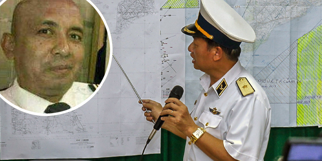 Vietnamese Navy's Deputy Commander Rear Admiral Le Minh Thanh (R) points at a map to show the area where Vietnam is conducting search activities for the missing Malaysia Airlines flight 370 in Phu Quoc island on March 12, 2014. Vietnam said on March 12 it had suspended its air search for missing flight MH370 and scaled back a sea search as it waited for Malaysia to clarify the potential new direction of the multi-national hunt.        AFP PHOTO / LE QUANG NHAT