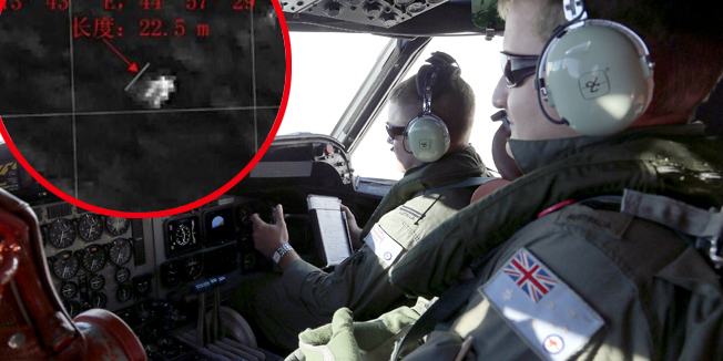 Australian flight engineer Sargent Jush Rumis (R), on board a Royal Australian Air Force AP-3C Orion, keeps a look out in the cockpit as they search for missing Malaysia Airlines flight MH370 debris or wreckage in the southern Indian Ocean on March 22, 2014. The Orion under took a four-hour journey to search an area approximately 2,500 kms southwest of Perth, two hours on station searching at about 400 feet above the ocean, and then a four-hour return. China released on March 22 a new satellite image of a large floating object possibly linked to missing Malaysia Airlines flight MH370, boosting search efforts as anger with the pace of the operation boiled over among Chinese relatives in Beijing.  AFP PHOTO / POOL / Rob Griffith