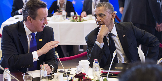 British Prime Minister David Cameron (L) speaks with US President Barack Obama as they participate in a session dedicated to the global economy during the G7 Summit at the European Council in Brussels, Belgium, on June 5, 2014.  AFP PHOTO / SAUL LOEB