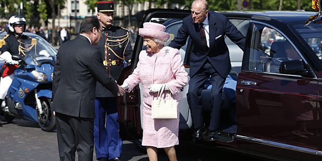 Britain's Queen Elizabeth II (C) and her husband Prince Philip, Duke of Edinburgh (R), are greeted by French President Francois Hollande (L) as they arrive to attend a ceremony at the Arc de Triomphe in Paris, June 5, 2014. Britain's Queen Elizabeth II arrived in Paris on June 5 for an increasingly rare three-day state visit that will see her feted as France's 
