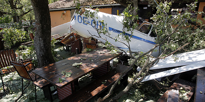 Vrsar, 060614.Neiskusni austrijski piloti spustajuci se na vrsarski aerodrom prevelikom su brzinom odskocili od piste, te im je avion skrenuo u obliznja stabla i zaustavio se na terasi kafica.Avion je u potpunosti unisten, a pilot i kopilot su izasli neozlijedjeni iz aviona.Na mjestu nesrece su policajci koji vrse ocevid.Na fotografiji: srusen avion.Foto: Goran Sebelic / CROPIX                              
