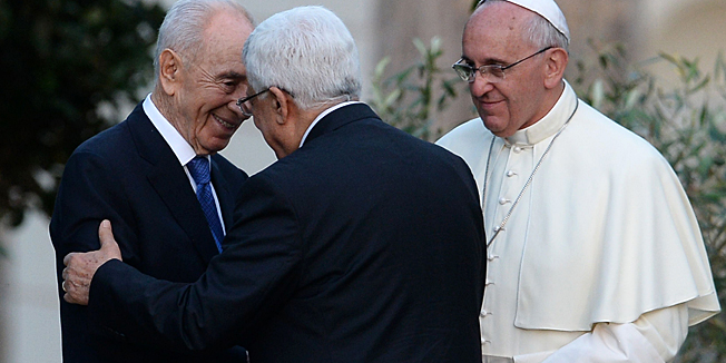 Israeli President Shimon Peres (L) shakes hands with Palestinian leader Mahmud Abbas as Pope Francis looks on after they plant an olive tree in the Vatican's gardens following a joint peace prayer on June 8, 2014 at the Vatican. The Vatican has defined the meeting between Israeli President Shimon Peres and Israeli President Shimon Peres as an 