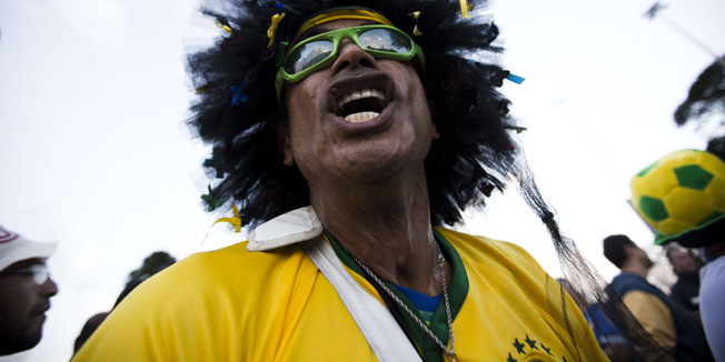 A Brazilian fan plays a drum as he shouts to support his team outside the Corinthians Arena in Sao Paulo, on June 11, 2014, ahead of the 2014 FIFA World Cup. AFP PHOTO/BEHROUZ MEHRI